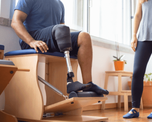 Man with leg prosthesis doing physical therapy exercises indoors