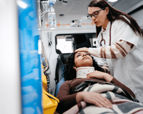 Injured woman with neck brace receiving care in ambulance.