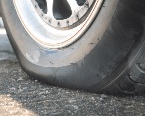 Close-up of a damaged vehicle tire with visible sidewall wear and deformation, illustrating tire defects such as sidewall failure or internal damage that can contribute to traffic accidents in Columbus, Georgia.