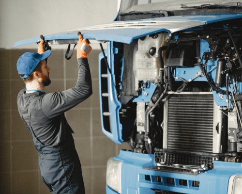 A mechanic looking into the engine of a semi truck