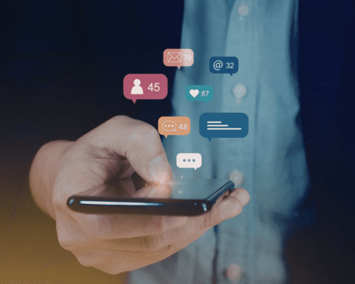 Person holding a smartphone with social media notification icons floating above the screen, illustrating how online activity can be monitored and used as evidence in a Savannah car accident injury claim.