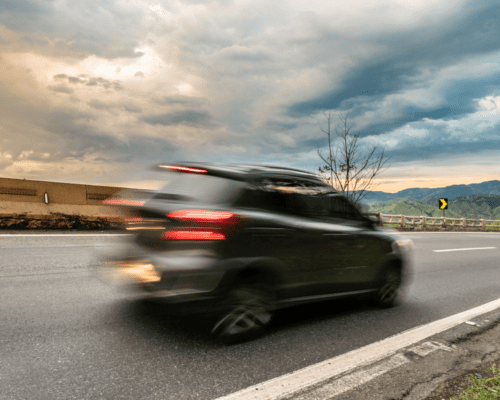 Blurred vehicle traveling at high speed on a roadway, illustrating a speeding driver scenario where evidence such as crash reports, black box data, and expert analysis may be used to prove negligence in a Savannah car accident claim.