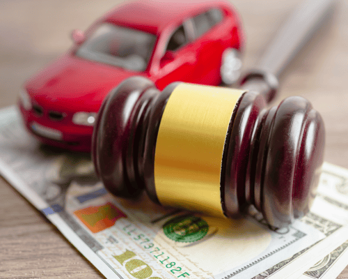 Judge's gavel resting on U.S. currency beside a model vehicle, representing an Atlanta car accident contingency fee lawyer, no win no fee car accident claims, Georgia personal injury compensation, and legal representation with no upfront attorney fees.